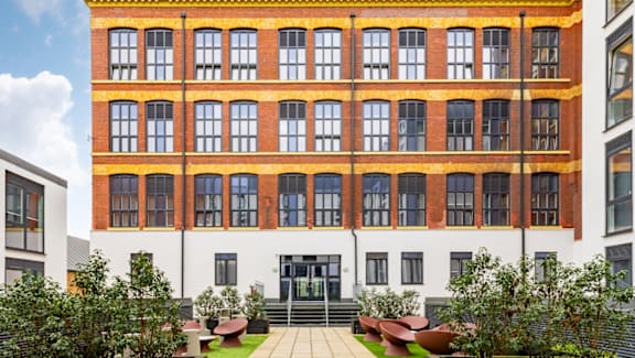 A large building with a red brick facade and a white section to the left.