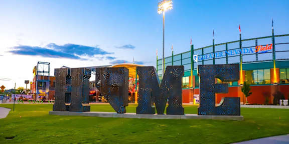 A large outdoor sign that says "HOME" in front of a stadium.