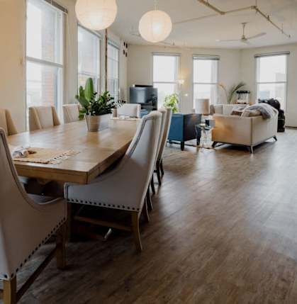 a large living room with a long wooden table and chairs