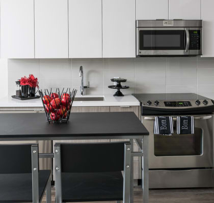 a kitchen with a black counter top and stainless steel appliances