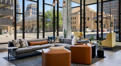 a lounge area with couches and chairs in front of a building