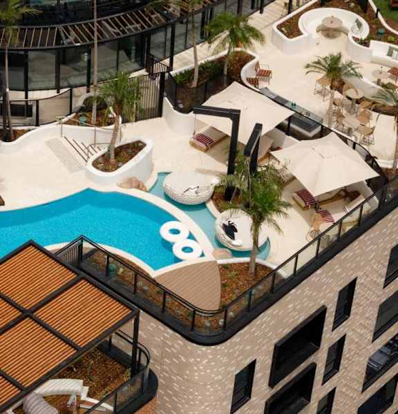 A rooftop pool area with a slide and lounging areas.