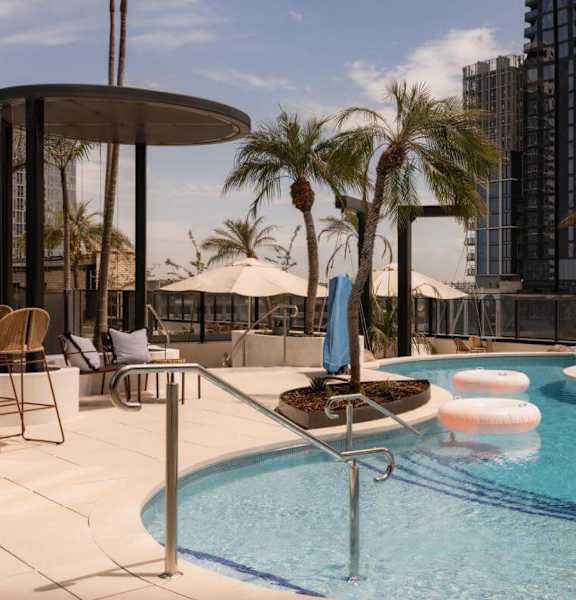 A pool with a blue umbrella and a white one.