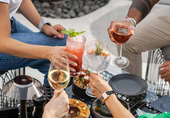 A group of people toasting with drinks at a table.