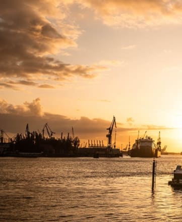 a sunset over a harbor with boats and ships