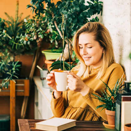 a woman sitting at a table with a cup of coffee