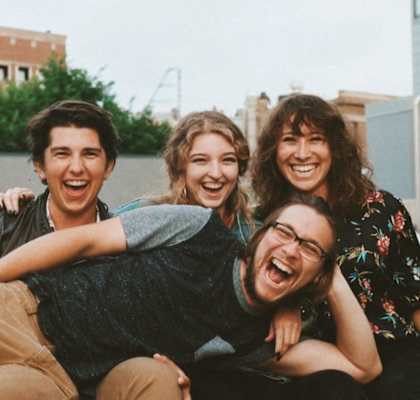 a group of friends sitting on top of each other