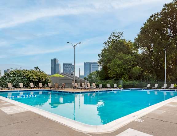 A large swimming pool with a city skyline in the background.