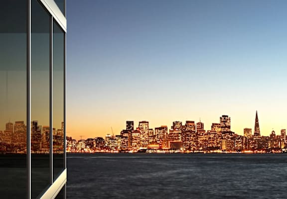 a view of a city skyline at dusk reflected in a window