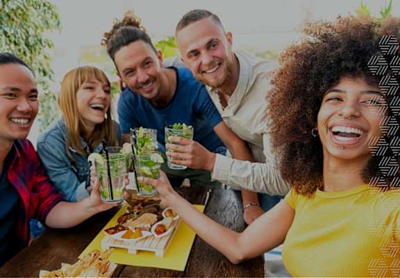 a group of people sitting around a table with drinks