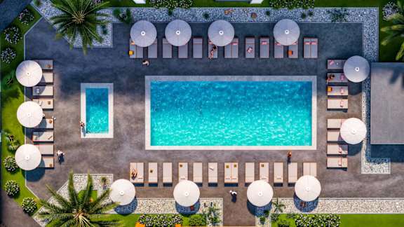 An aerial view of a pool surrounded by lounge chairs and umbrellas.