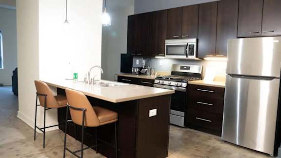 a kitchen with stainless steel appliances and wooden cabinets at Market Square Place, Pittsburgh, PA, 15222