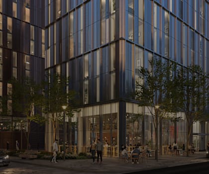A modern glass building with people walking outside.