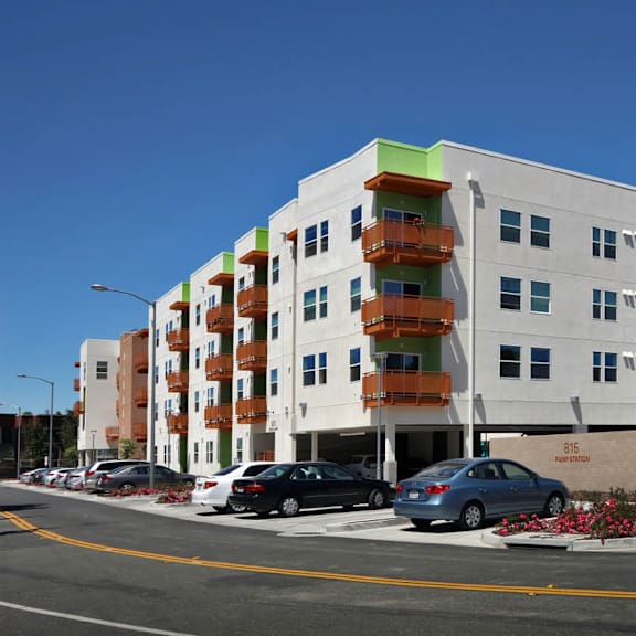 The front of the Mesa Vista Apartments building with a flag flying in the background.