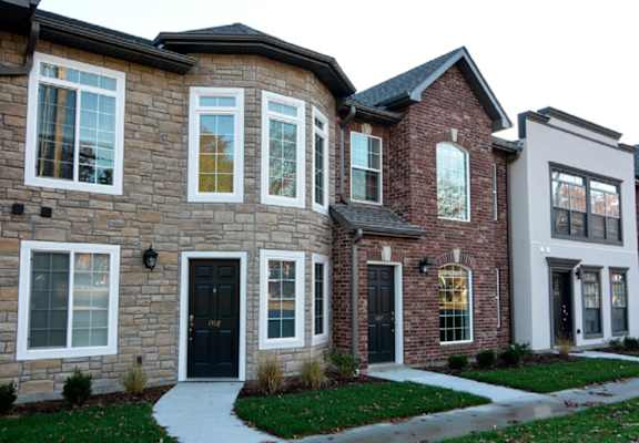 a large brick house with a sidewalk in front of it