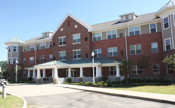 a large brick building with a porch and a driveway