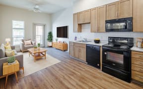 a kitchen and living room with wooden floors and wooden cabinets at Perkins Square Apartments