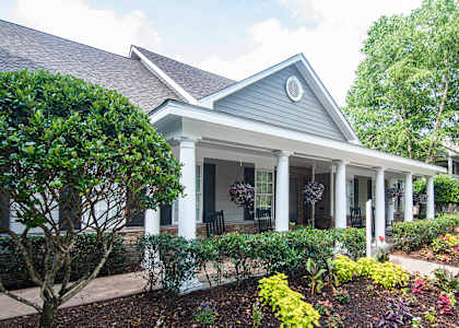 the front of a house with a porch and landscaping