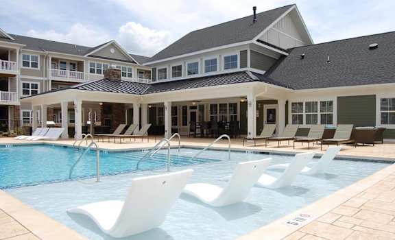 Swimming pool with loungers at Fox Hunt Farms apartments in Fort Mill, SC