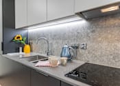 Thumbnail 7 of 16 - a kitchen counter with a sink and a kettle on it