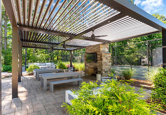 a patio with a picnic table and a stone fireplace