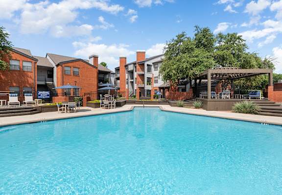 a large swimming pool with apartments in the background
