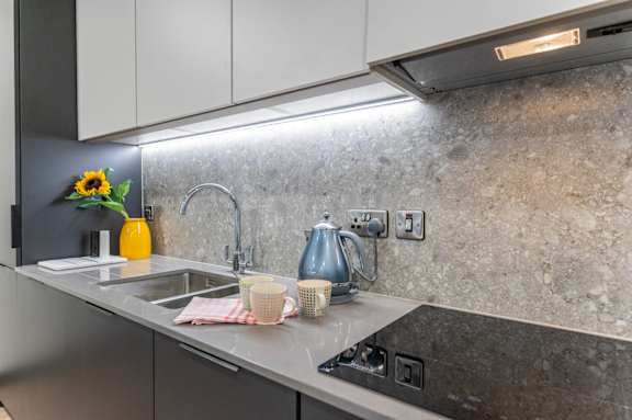 a kitchen counter with a sink and a kettle on it
