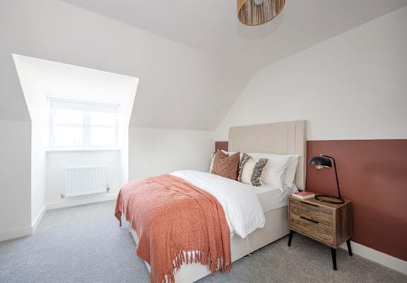 a bedroom with a bed and a dresser and a window