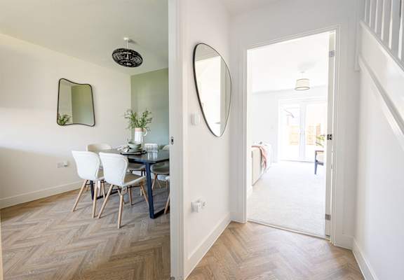 a dining room with a table and chairs and a mirror