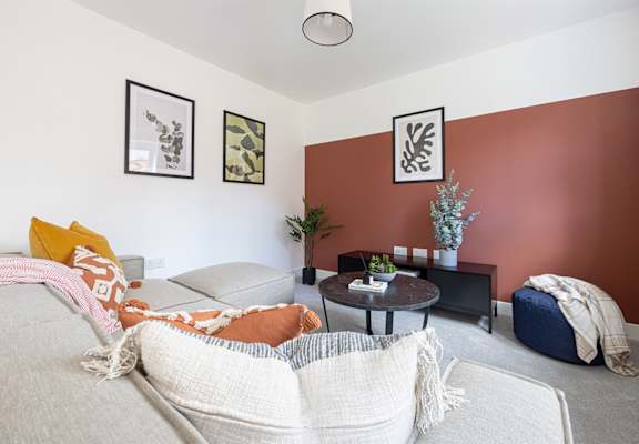 a living room with white furniture and a red accent wall