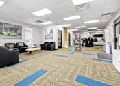 Thumbnail 3 of 5 - A spacious room with a car poster on the wall and a blue exit sign.