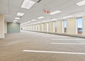Thumbnail 6 of 9 - A large, empty parking garage with a red exit sign.