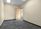 Thumbnail 7 of 13 - A room with a carpeted floor and a door.