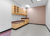 Thumbnail 6 of 13 - A room with a bench and storage drawers.