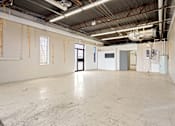 Thumbnail 2 of 5 - A large, empty industrial space with a concrete floor and walls.