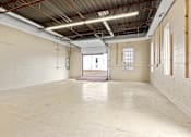 Thumbnail 5 of 5 - Empty industrial space with white walls and a concrete floor.