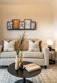 a bedroom with a bed and a nightstand with a lamp and a framed picture