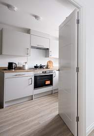 a modern kitchen with grey cabinets and black appliances