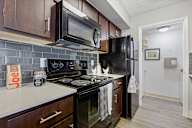 A kitchen with black appliances and brown cabinets