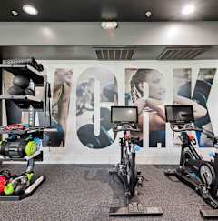 A room with exercise equipment and a wall with a large letter "A" on it.