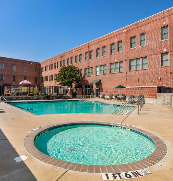 a swimming pool with a brick building in the background