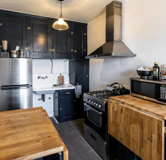 a kitchen with a wooden table and a stove and refrigerator