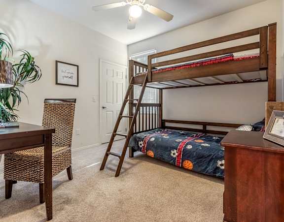 a bedroom at Beecher Terrace apartments with two windows and a bed with white sheets and pillows