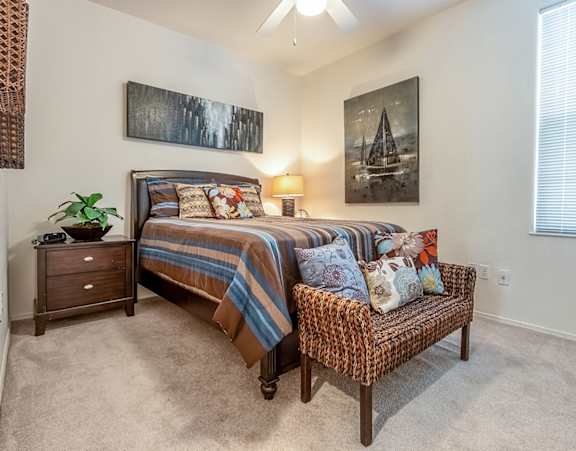 a bedroom with a bed with pillows and two lamps