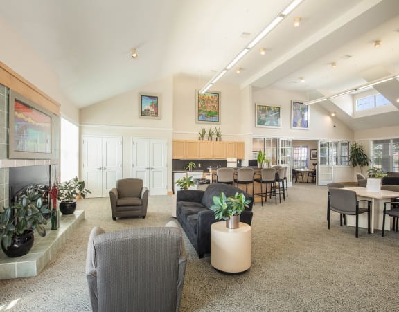 a living room with a couch and a dining table and a refrigerator surrounded by cabinets