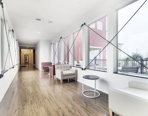 a common area with chairs and large windows at Villas on the Strand apartments in Galveston, TX