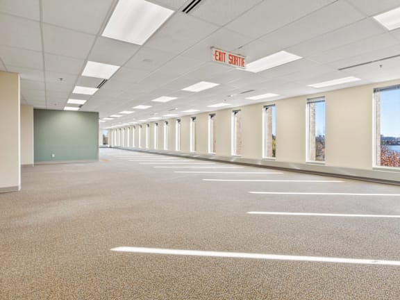 A large, empty parking garage with a red exit sign.