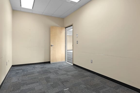A room with a carpeted floor and a door.