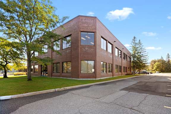 A red brick building with a parking lot in front.