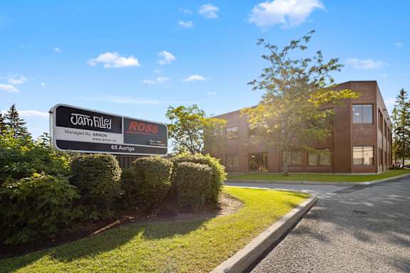 A sign for a property managed by Van Filtler is in front of a building.
